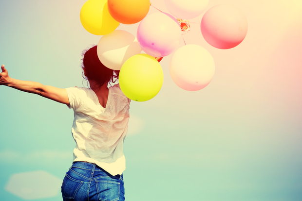 Happy woman jumping for joy with balloons Happy woman jumping for joy with balloons
