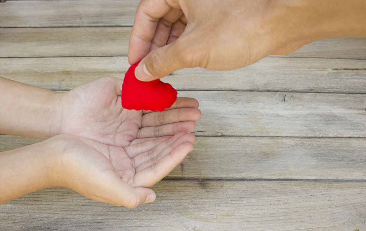 Hand handing over a heart Hand handing over a heart