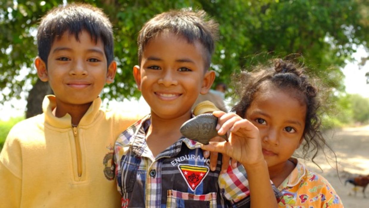 Children holding lucky iron fish Children holding lucky iron fish
