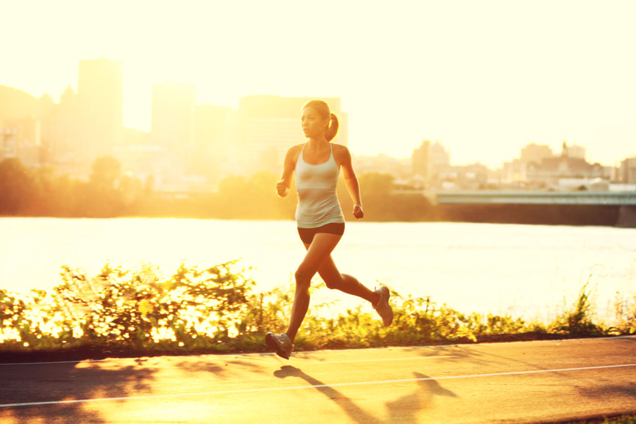 female runner running at sunset in city park. female runner running at sunset in city park.
