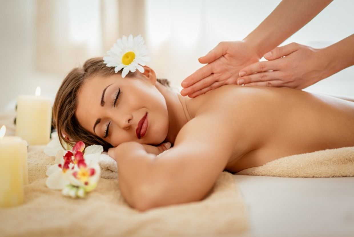 Woman enjoying during a back massage at a spa. Woman enjoying during a back massage at a spa.