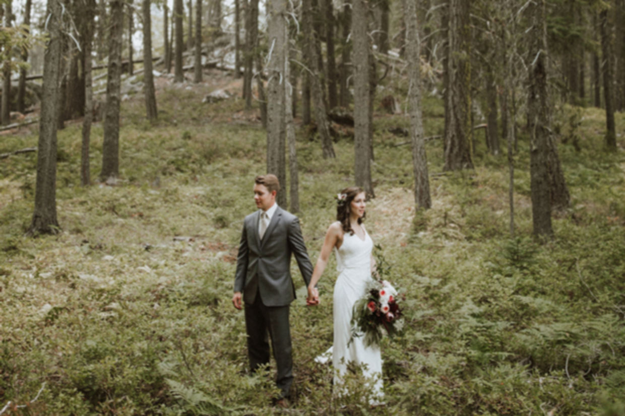A couple in wedding dress and suit stand in the forest. A couple in wedding dress and suit stand in the forest.