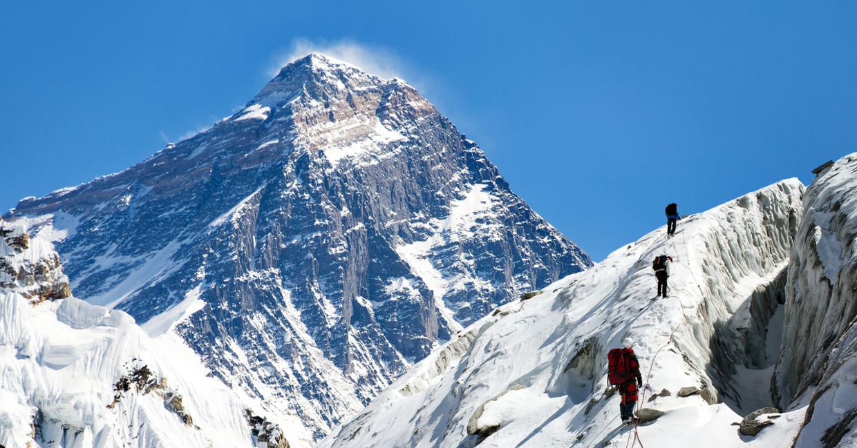 View of Everest from Gokyo valley with a group of climbers on a glacier on their way to Everest base camp View of Everest from Gokyo valley with a group of climbers on a glacier on their way to Everest base camp