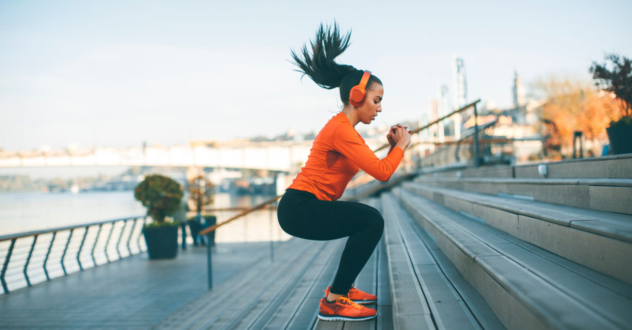 Woman with headphones exercising outside Woman with headphones exercising outside