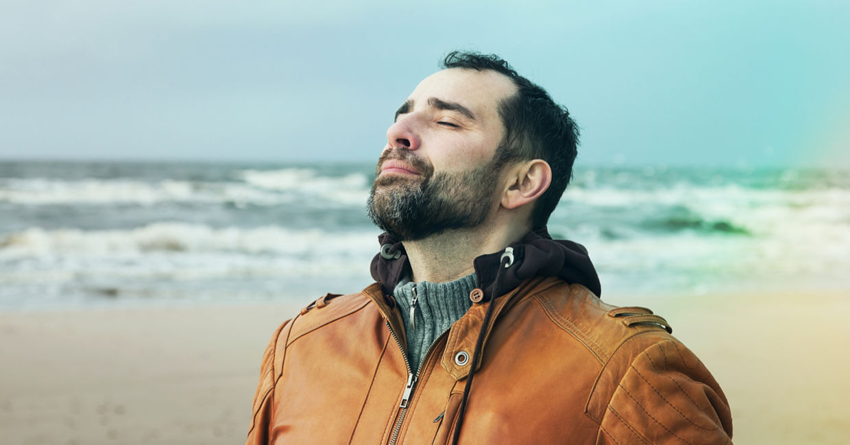 A man on the beach doing deep breathing exercises. A man on the beach doing deep breathing exercises.