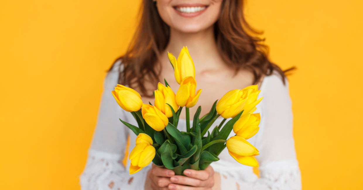 Photo of happy woman holding flowers to illustrate kindness Photo of happy woman holding flowers to illustrate kindness