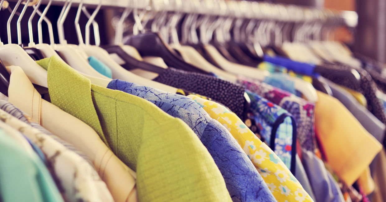 Closet full of clothes on different colored hangers Closet full of clothes on different colored hangers