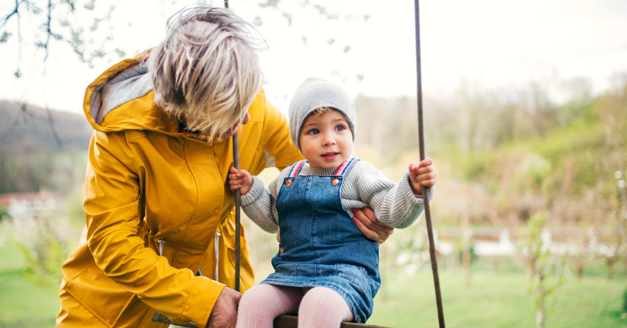 Grandmother helping a little kid on a swing Grandmother helping a little kid on a swing