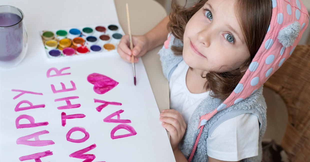 A young girl paints a Mother’s Day card. A young girl paints a Mother’s Day card.