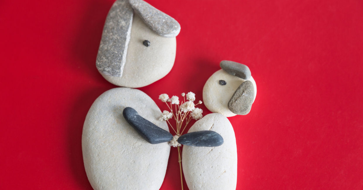 Pebble art shows a mother and child holding hands. Pebble art shows a mother and child holding hands.