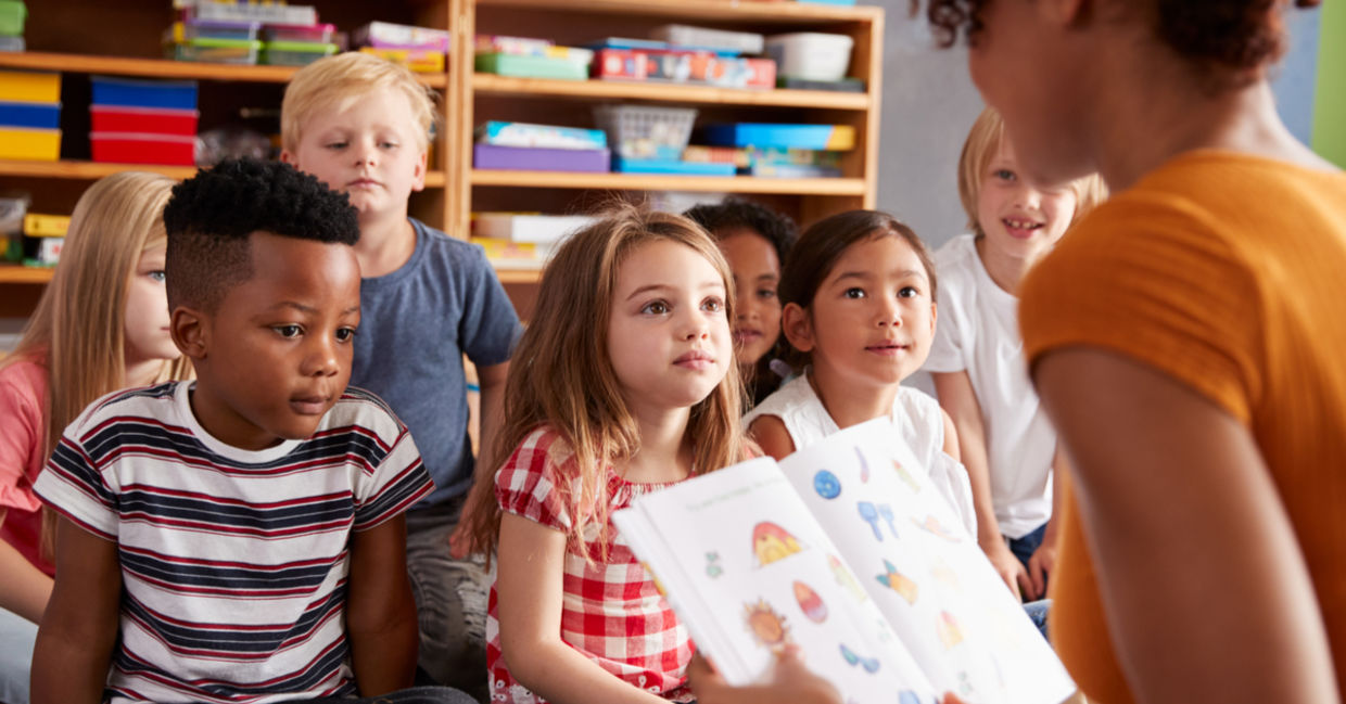 A teacher reads a story to young students. A teacher reads a story to young students.