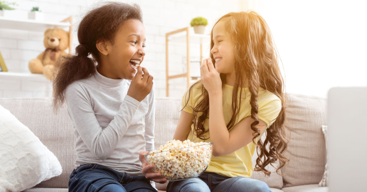 best friends snacking on popcorn. best friends snacking on popcorn.