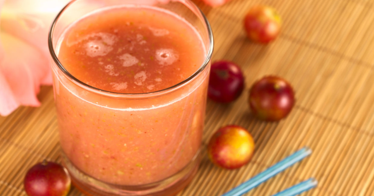 Camu camu berries beside a glass of freshly squeezed camu camu juice. Camu camu berries beside a glass of freshly squeezed camu camu juice.