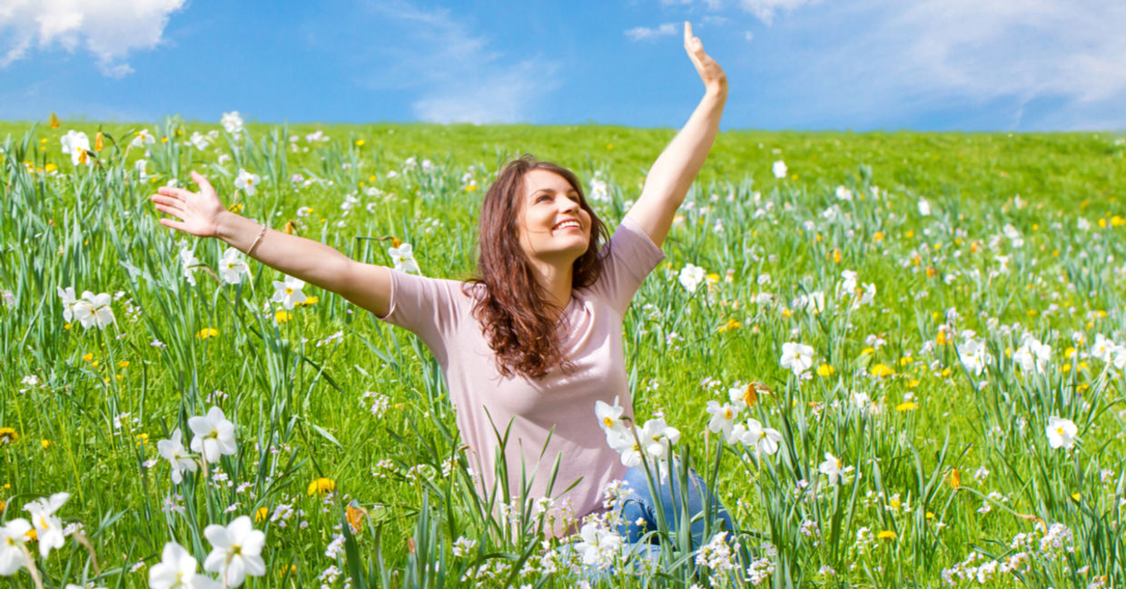 Happy woman sitting in a field of daffodils. Happy woman sitting in a field of daffodils.