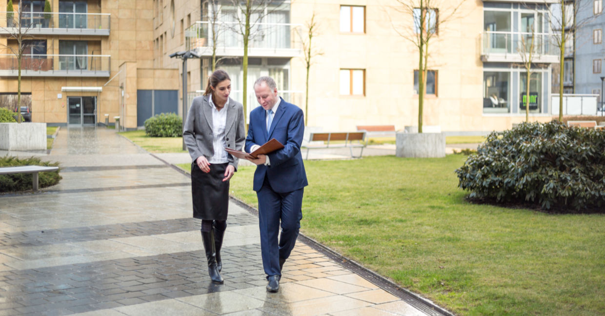 Two business people walking and discussing outside the office Two business people walking and discussing outside the office