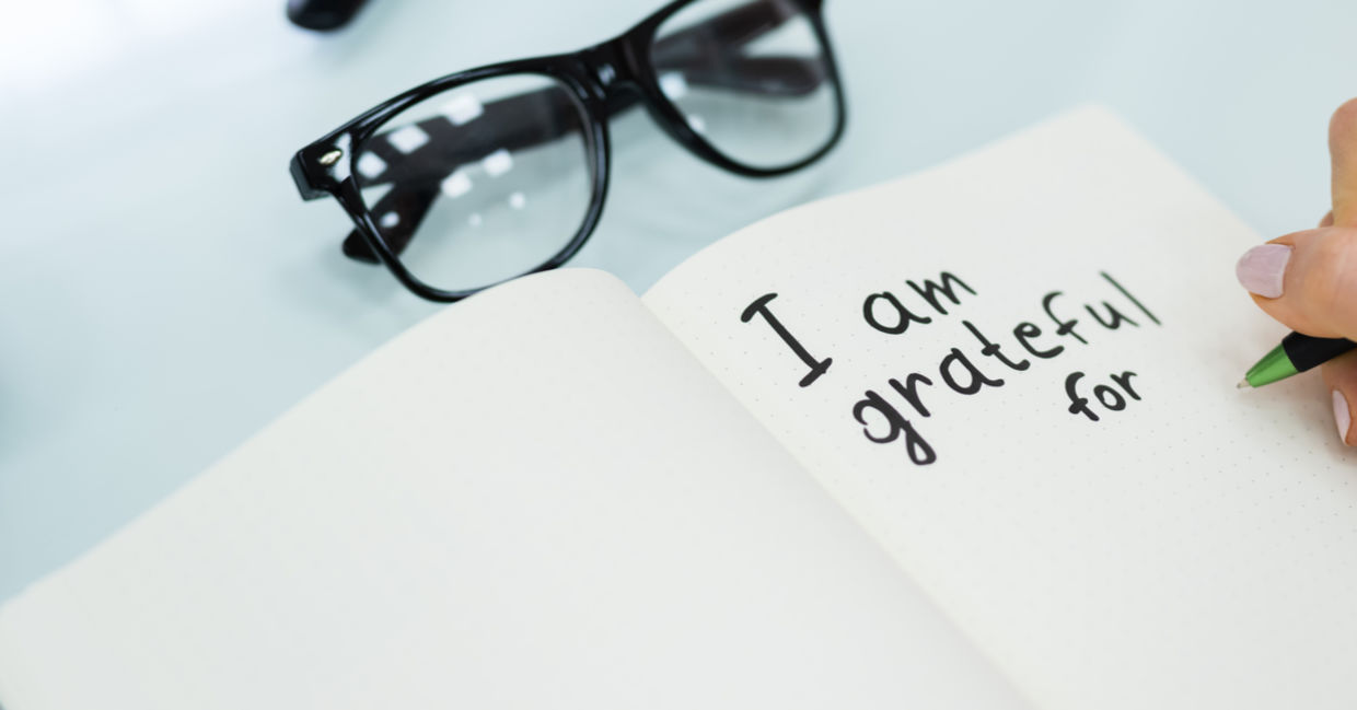 A woman writes in her gratitude journal. A woman writes in her gratitude journal.
