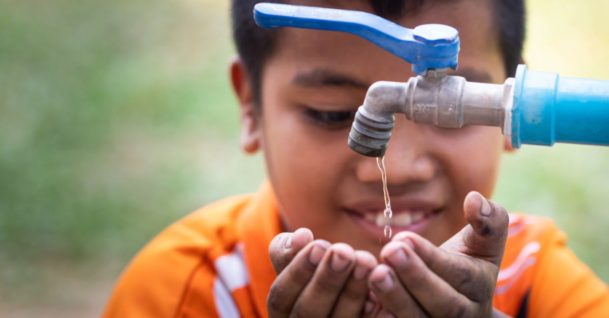 Boy drinking from an outdoor tap Boy drinking from an outdoor tap