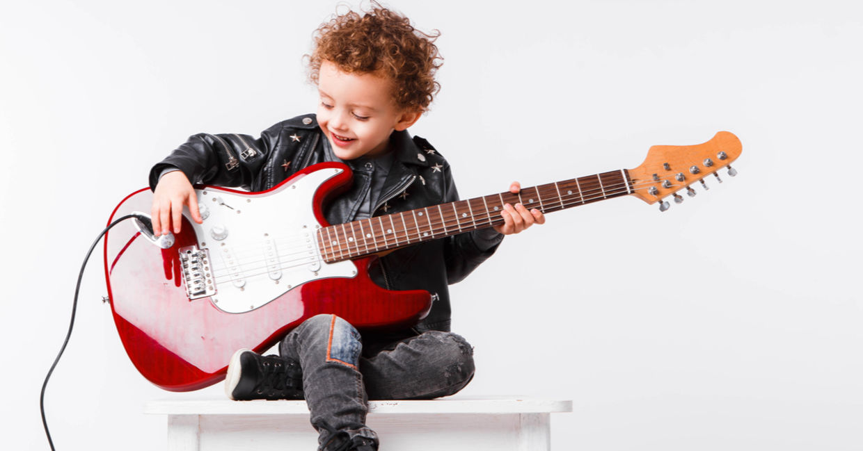 child playing an electric guitar. child playing an electric guitar.