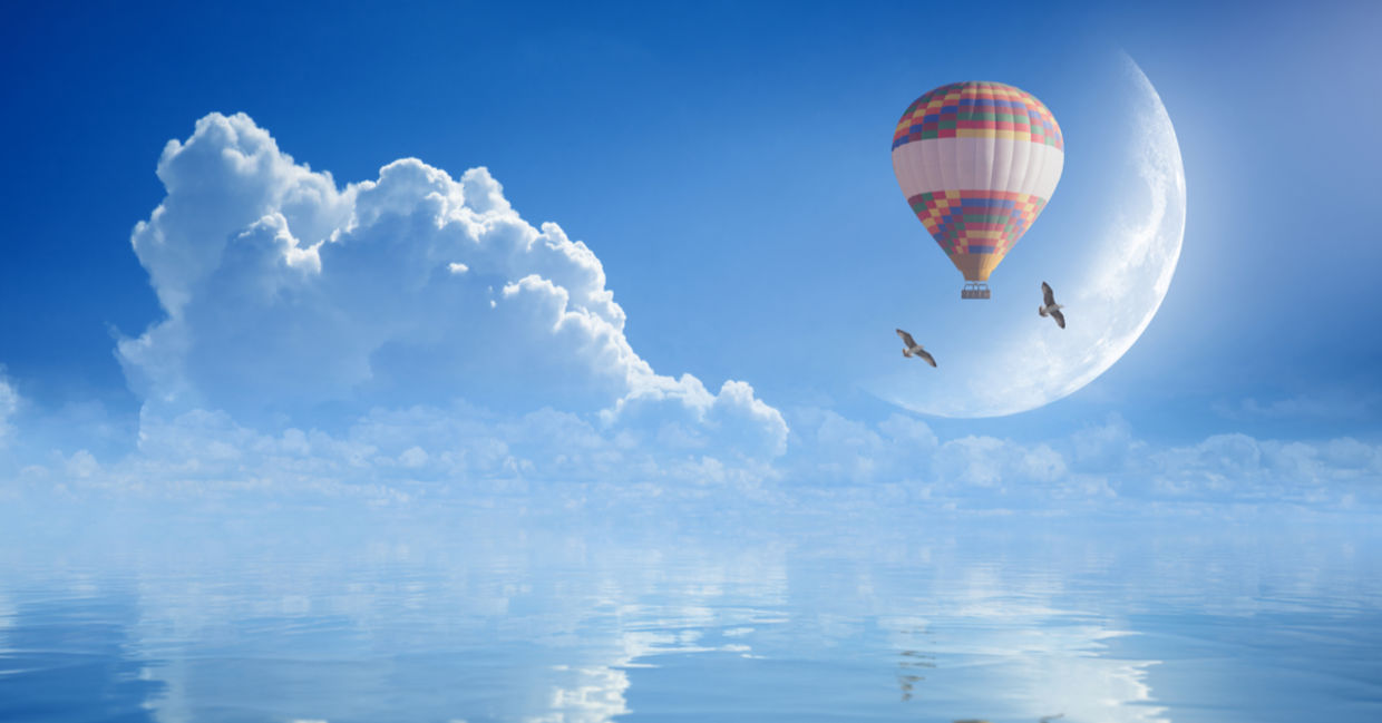 Idyllic image of hot air balloon and birds soaring to signify purpose Idyllic image of hot air balloon and birds soaring to signify purpose