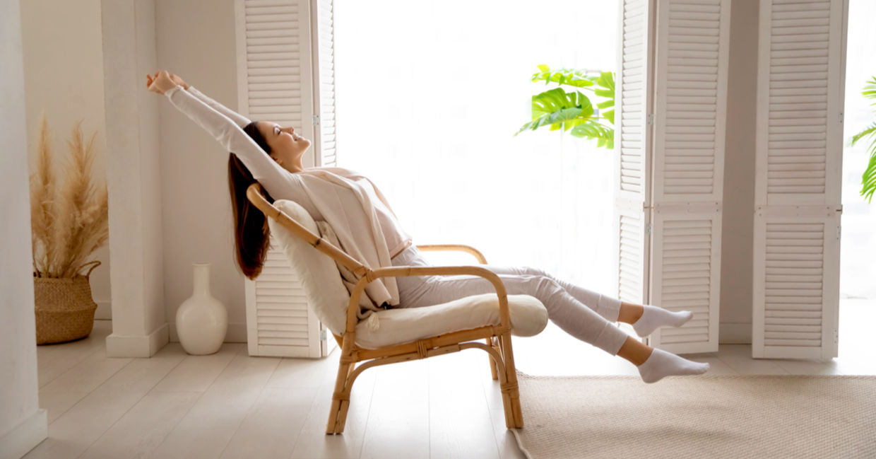Woman breathing in the fresh air after opening the window Woman breathing in the fresh air after opening the window