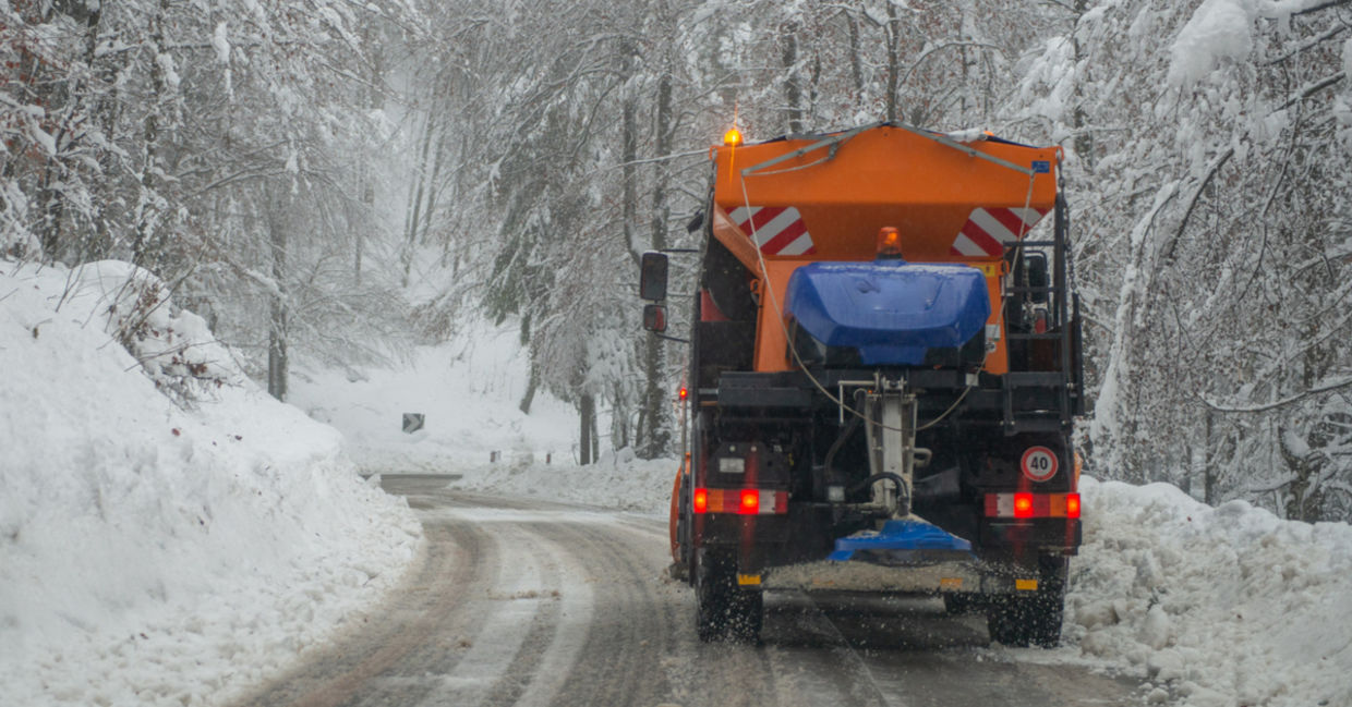 DE-icing truck on a snow-covered road. DE-icing truck on a snow-covered road.