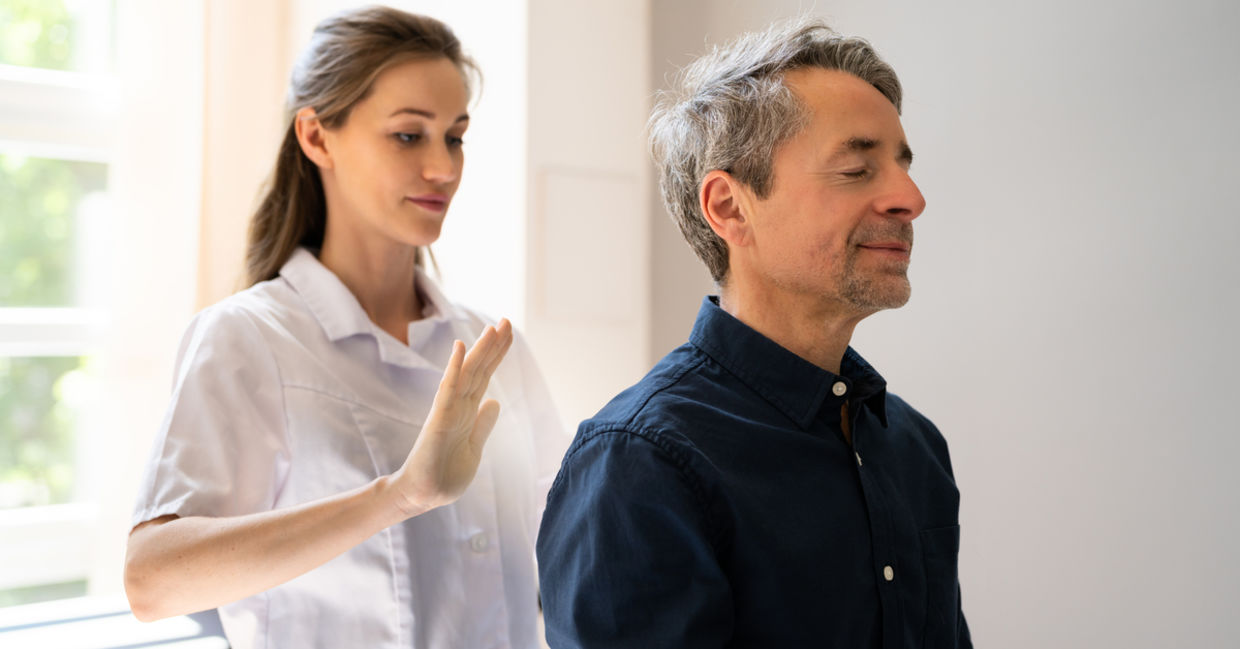 A man receives a healing reiki treatment. A man receives a healing reiki treatment.