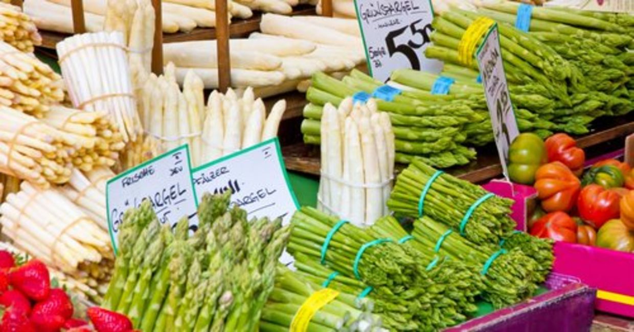 Green and white asparagus are displayed at a farmers’ market. Green and white asparagus are displayed at a farmers’ market.