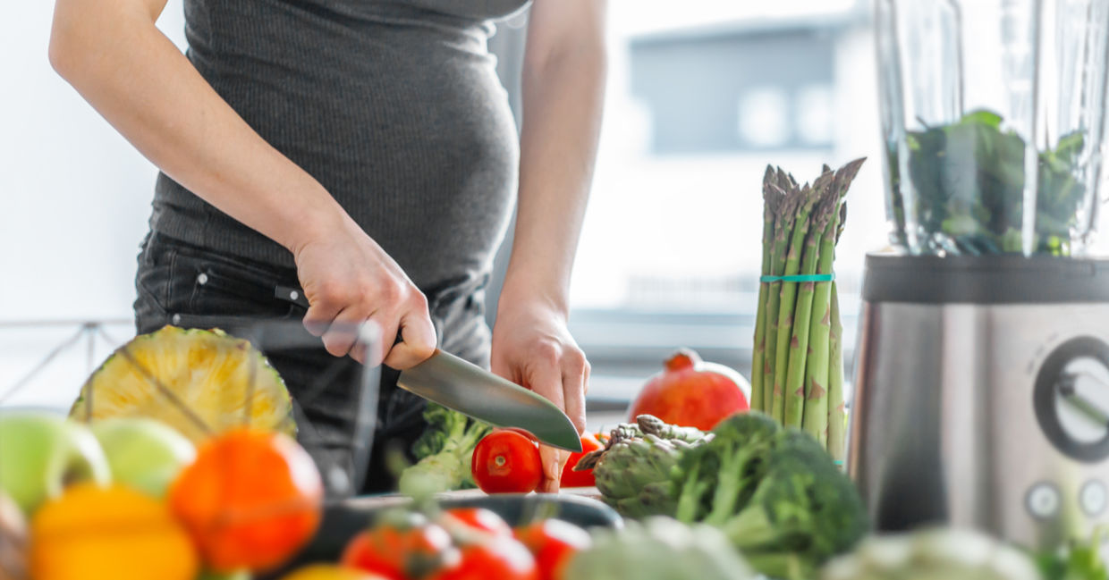 A pregnant woman prepares a healthy meal, including asparagus. A pregnant woman prepares a healthy meal, including asparagus.