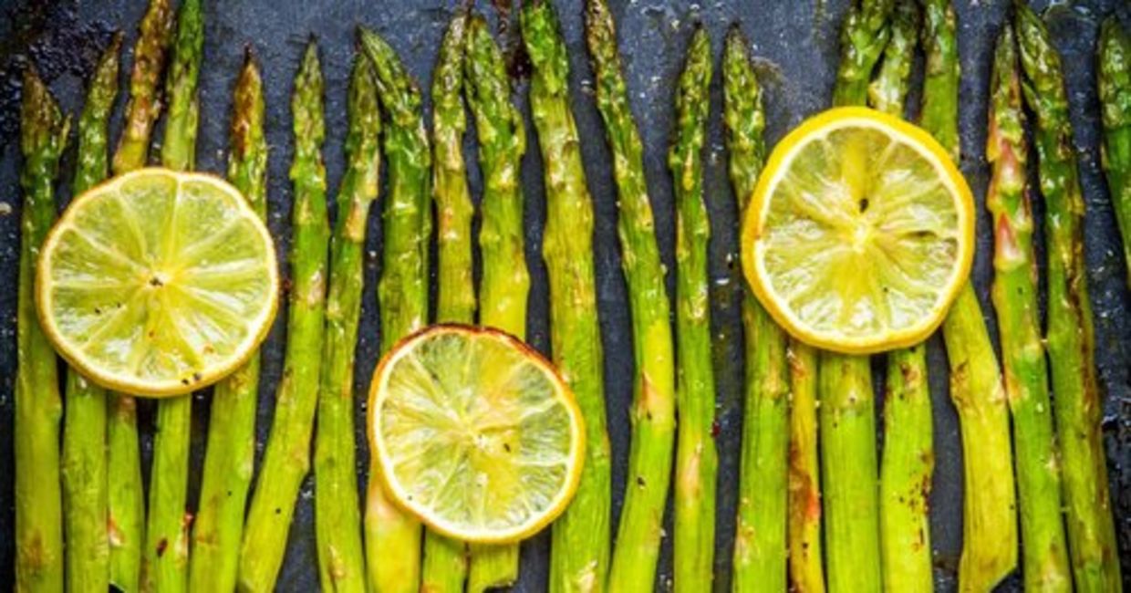 Baked asparagus is served with lemon slices. Baked asparagus is served with lemon slices.