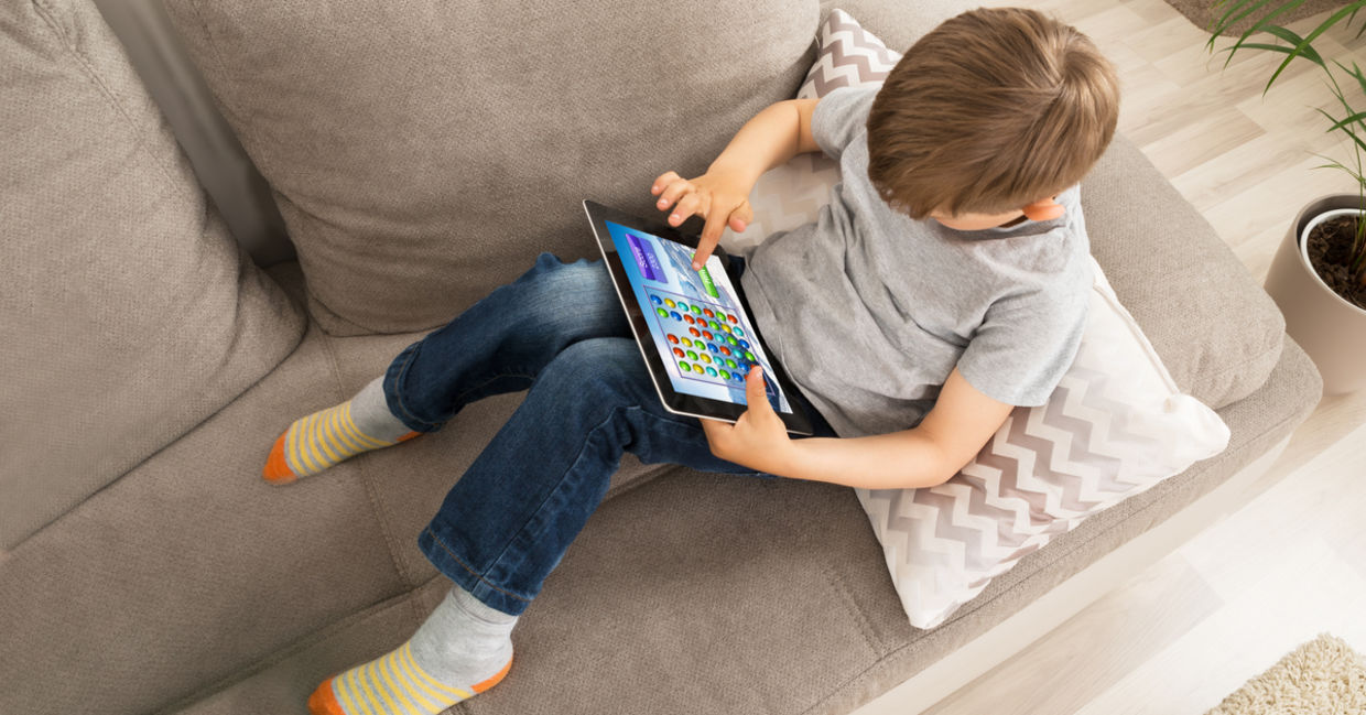 kid using an app on a tablet. kid using an app on a tablet.