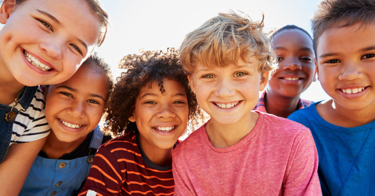 Close up of pre-teen friends in a park smiling to camera. Close up of pre-teen friends in a park smiling to camera.