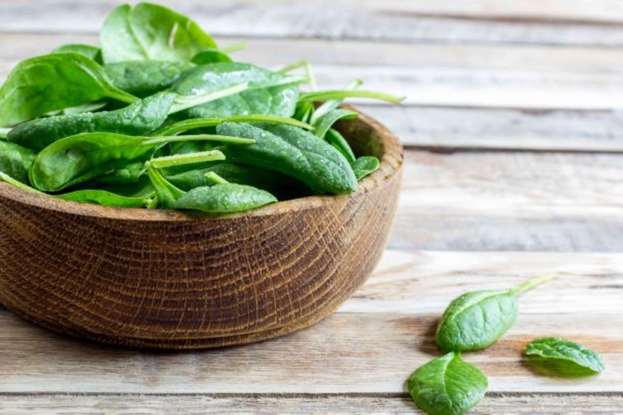 Fresh baby spinach in a wooden ball Fresh baby spinach in a wooden ball