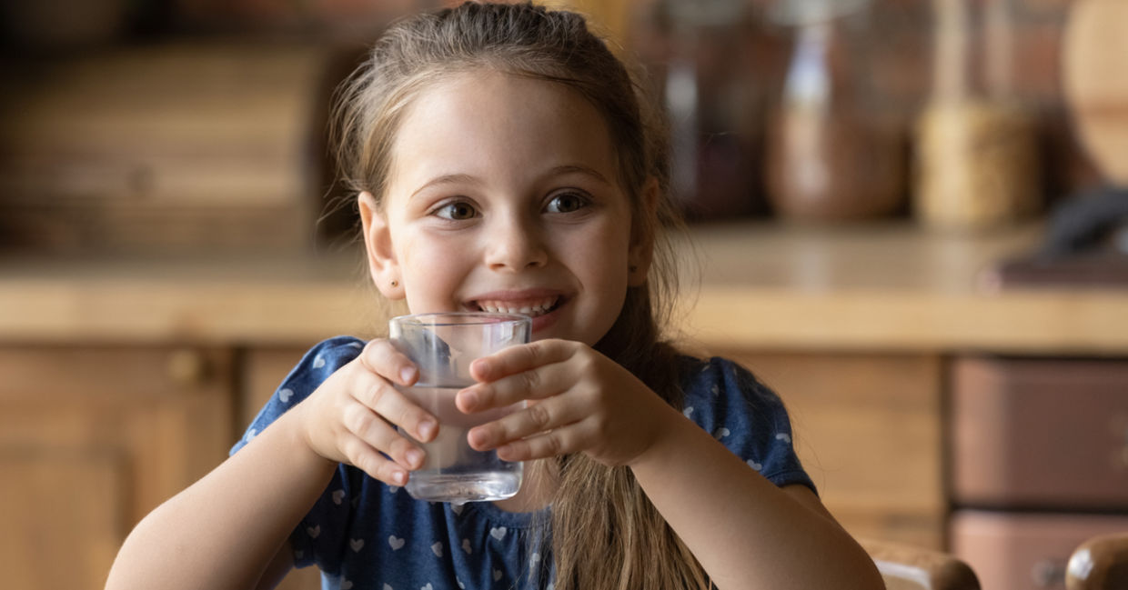 Girl enjoying quenching her thirst with clean mineral water from a glass. Girl enjoying quenching her thirst with clean mineral water from a glass.