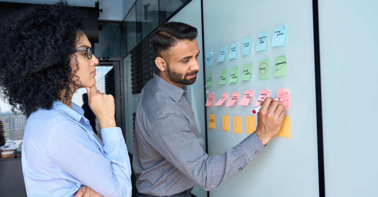 Businessman writing color-coded strategy ideas. Businessman writing color-coded strategy ideas.