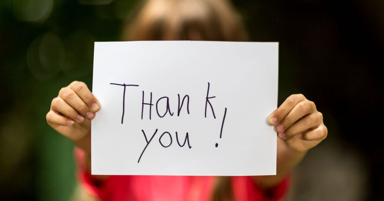 A girl holding a sign with the words Thank You. A girl holding a sign with the words Thank You.
