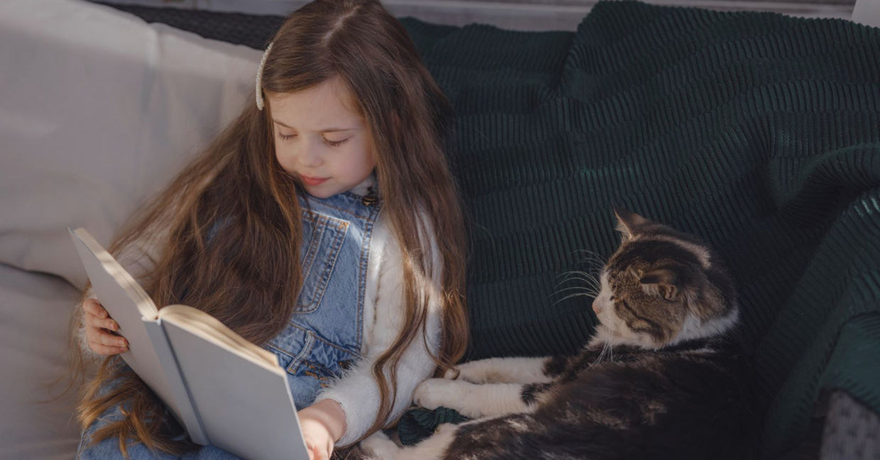 Young girl reading to her pet. Young girl reading to her pet.