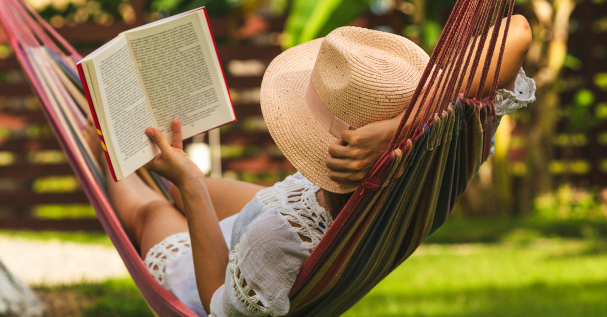 Woman in a hammock reading a book. Woman in a hammock reading a book.