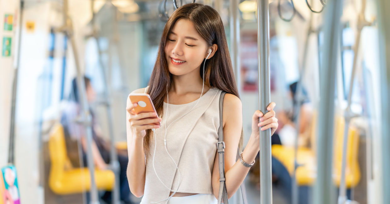 Young passenger listening to music during her commute. Young passenger listening to music during her commute.