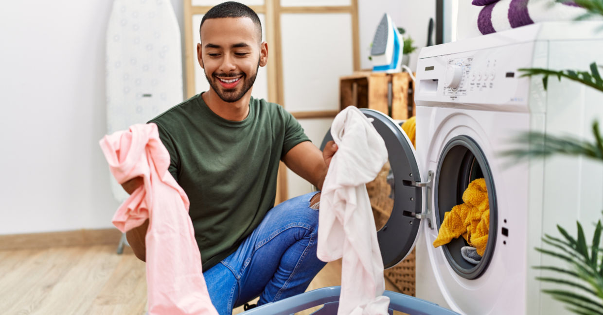 A man washing his clothing in cold water. A man washing his clothing in cold water.