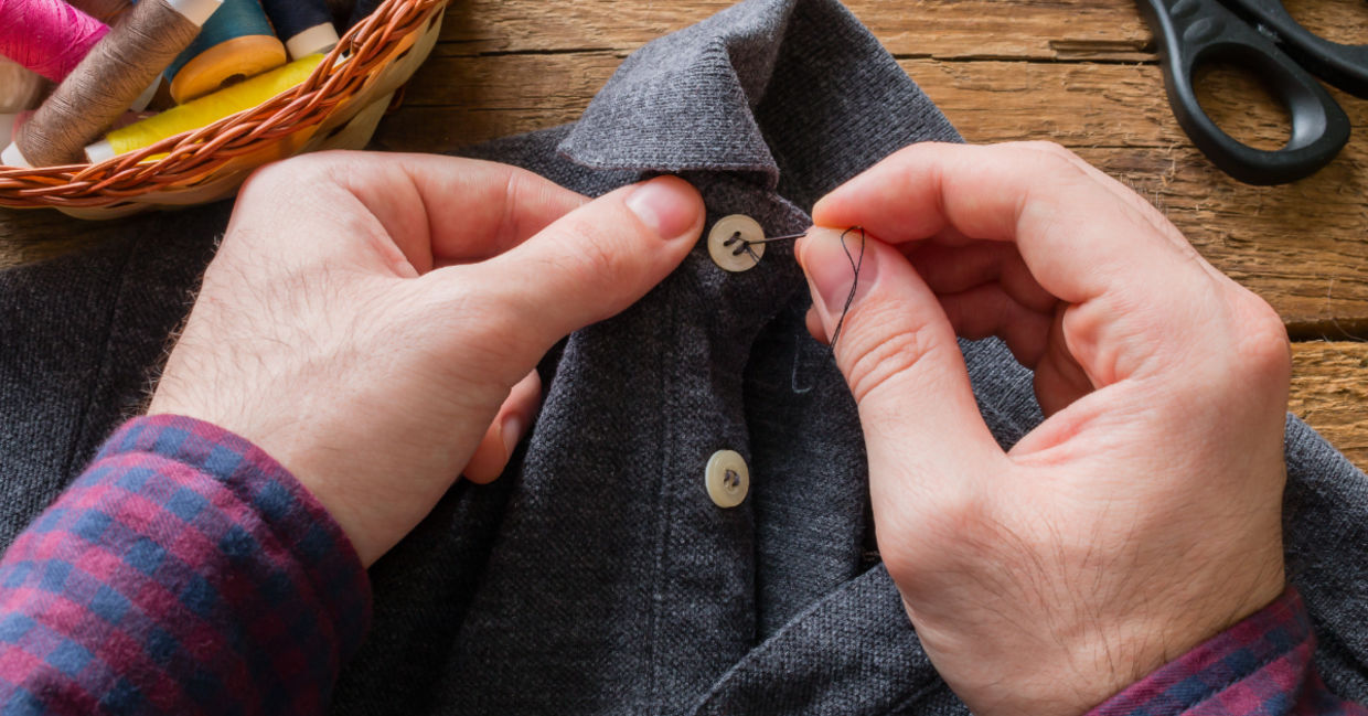 Main sewing a button on his shirt to make it last longer. Main sewing a button on his shirt to make it last longer.