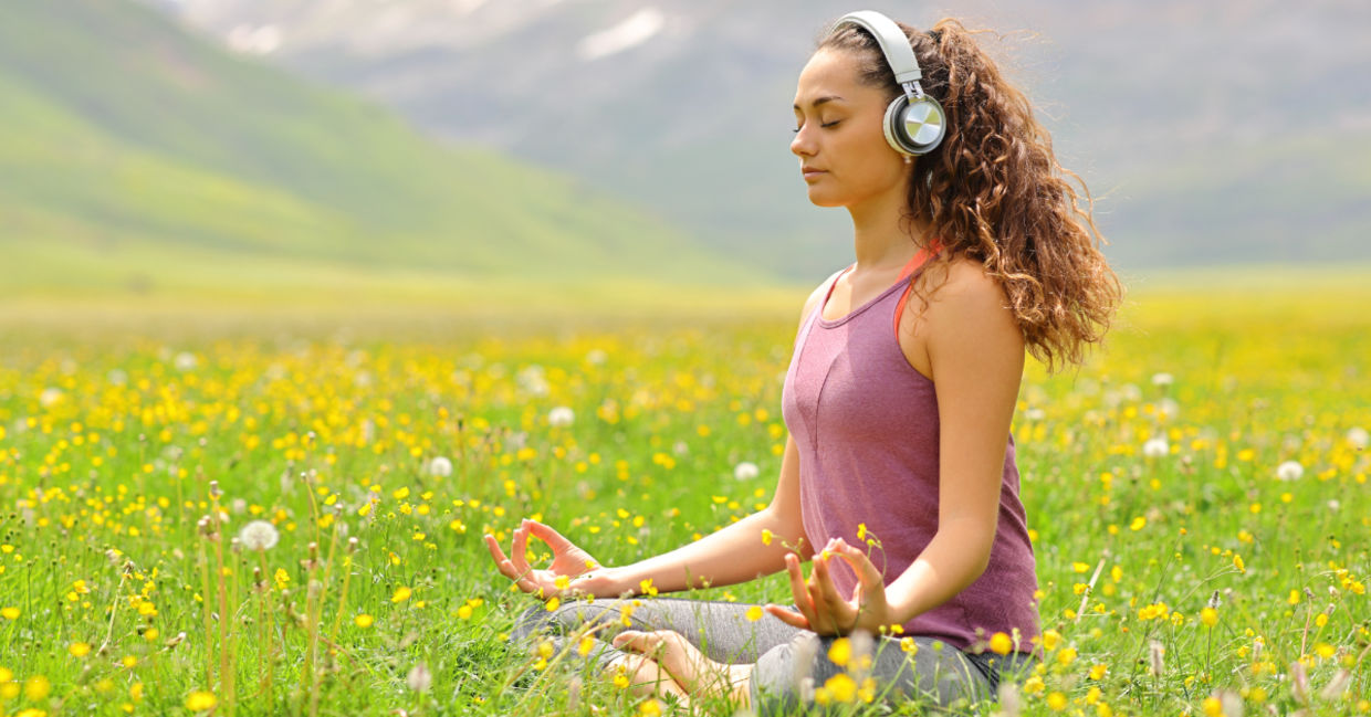 woman listening to guided meditation in nature woman listening to guided meditation in nature
