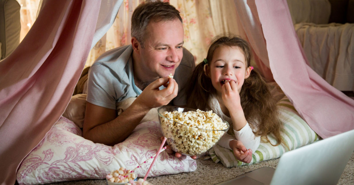 Father and daughter enjoying a dog-themed movie together. Father and daughter enjoying a dog-themed movie together.
