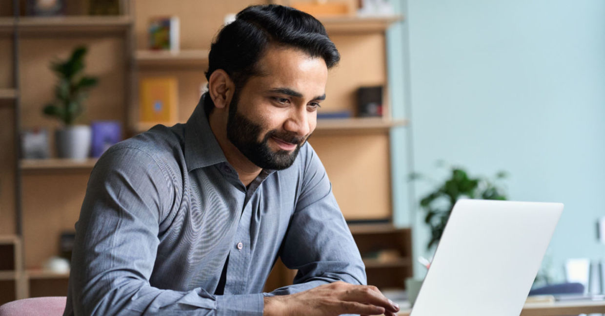 A man gazes down at his laptop, reducing eye strain. A man gazes down at his laptop, reducing eye strain.