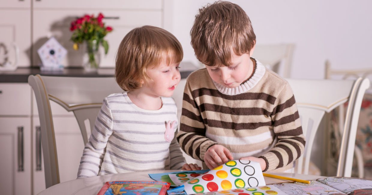 Two kids playing with stickers. Two kids playing with stickers.