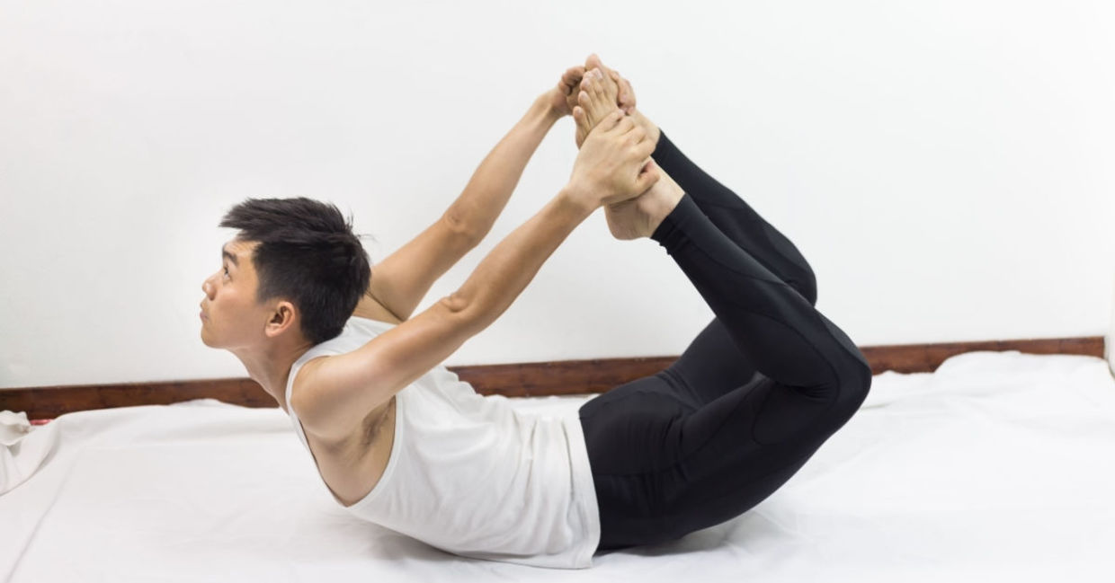 Man doing yoga poses in bed. Man doing yoga poses in bed.