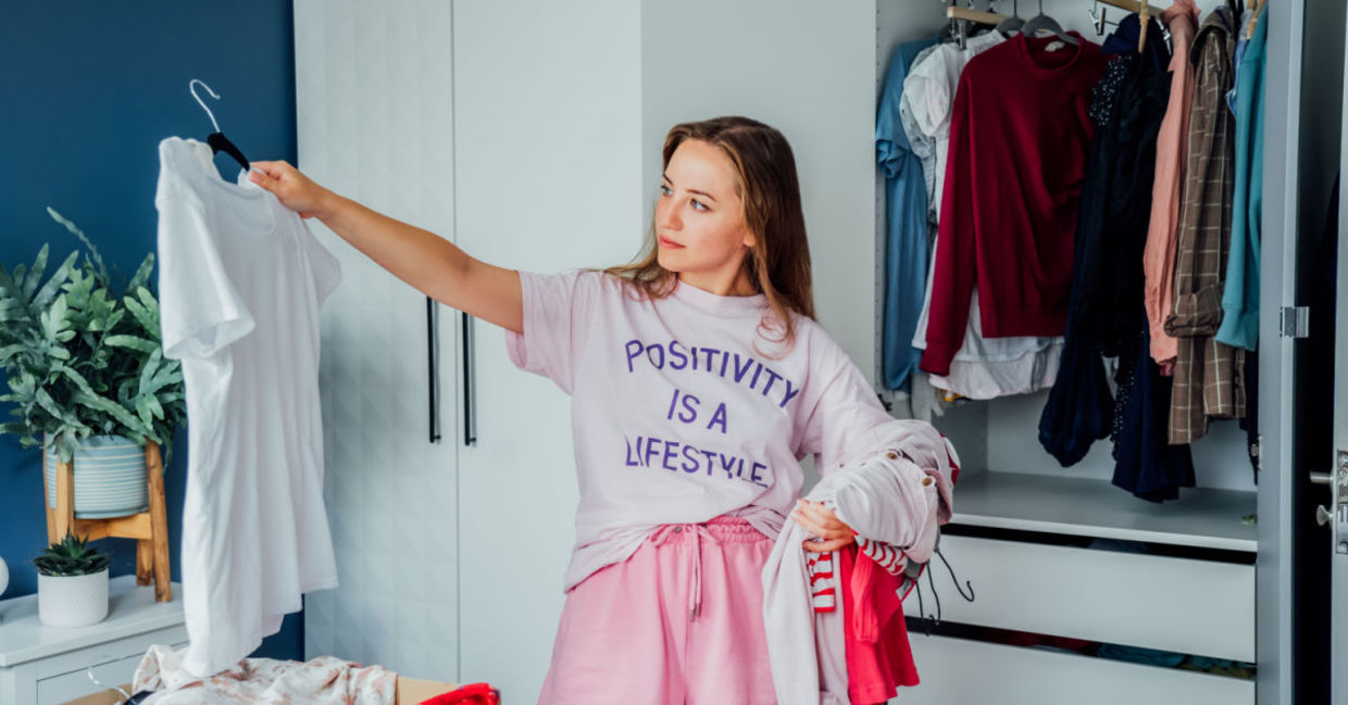 Woman cleaning out unwanted clothing from her closet. Woman cleaning out unwanted clothing from her closet.