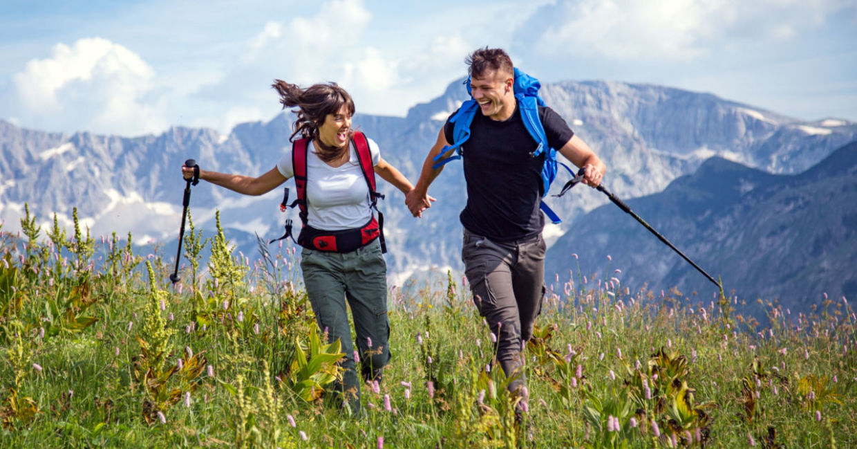 Hikers in a mountain meadow are exploring the world in a sustainable way. Hikers in a mountain meadow are exploring the world in a sustainable way.