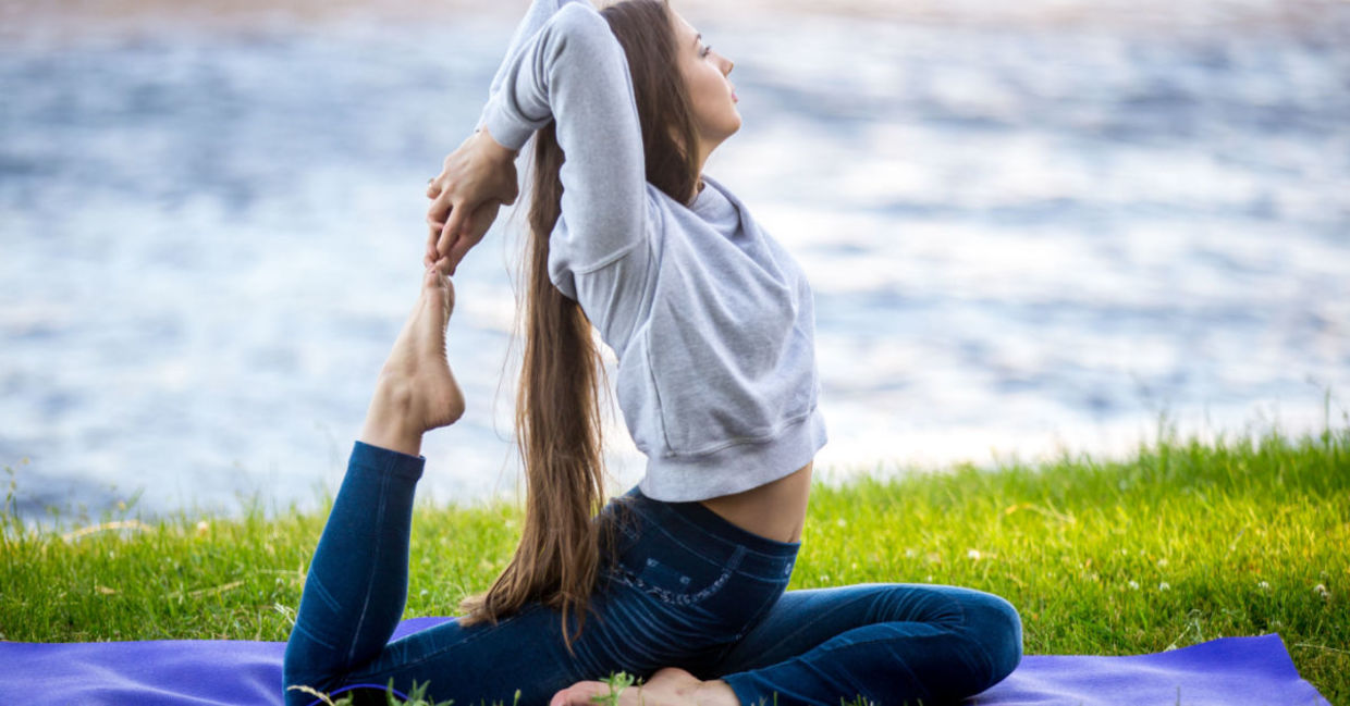 A woman grounding herself with the pigeon pose. A woman grounding herself with the pigeon pose.