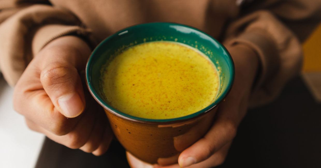 Man holding a cup of turmeric tea. Man holding a cup of turmeric tea.