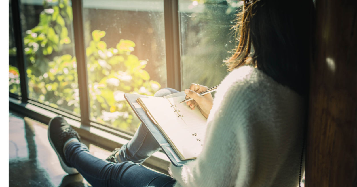 Woman writing her thoughts down in a journal. Woman writing her thoughts down in a journal.